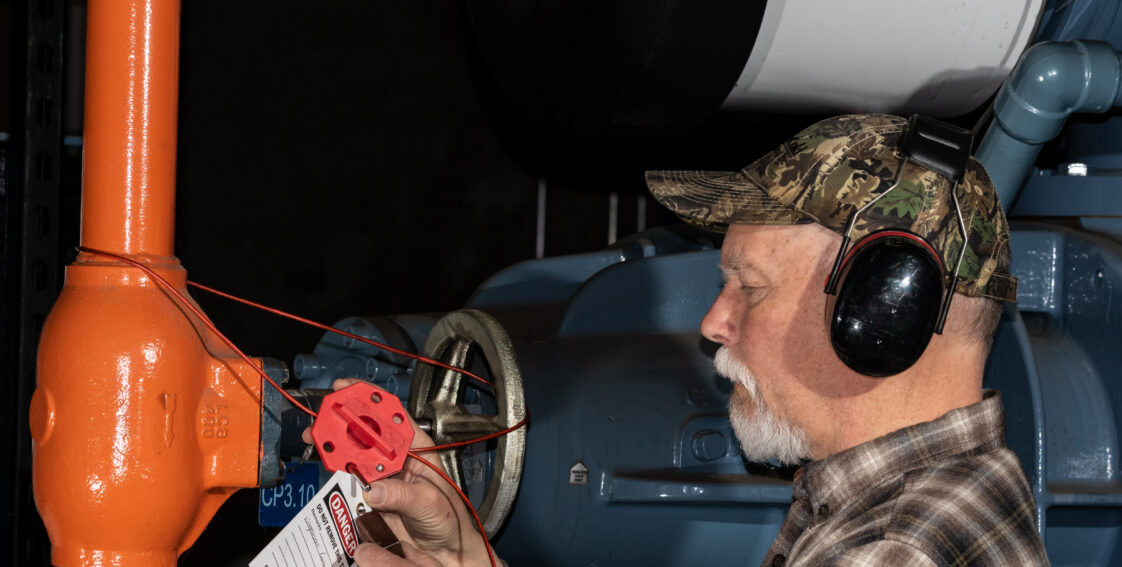 A technician applies a lockout tag to an ammonia valve